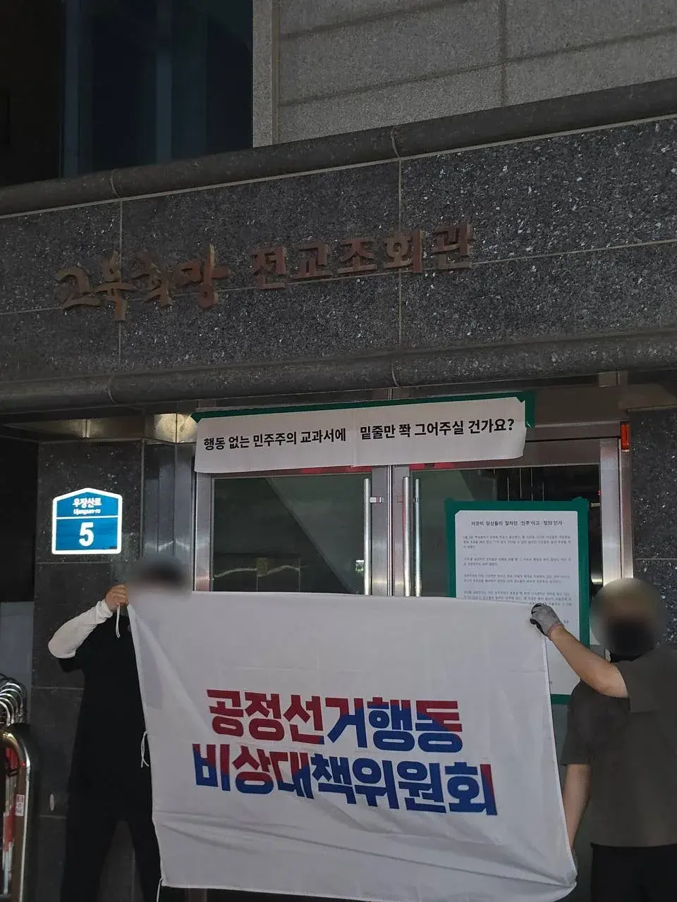 전국교직원노동조합 건물 앞에 행동 없는 민주주의 교육을 비판하는 표어와 대자보를 부착한 현장